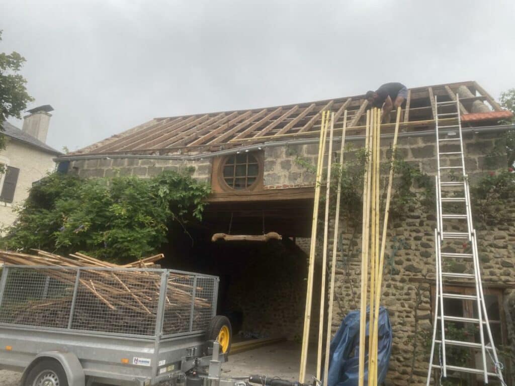 Un homme rénove le toit d'une maison.