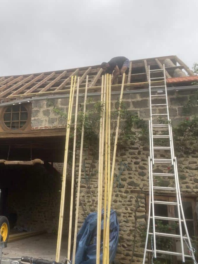 Un homme rénove le toit d'une maison.