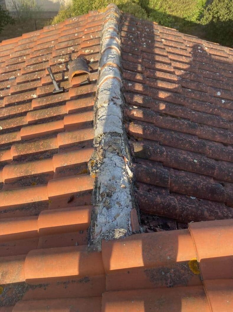 Le toit d'une maison avec une tuile cassée a besoin d'être rénové.